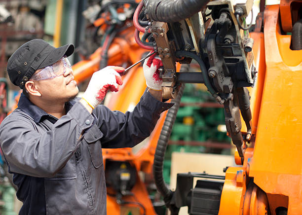 Mechanic repairing a robot machine